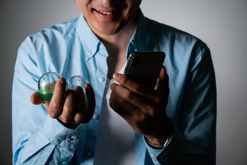ガチャとスマートフォンを持ってほくそ笑む男性