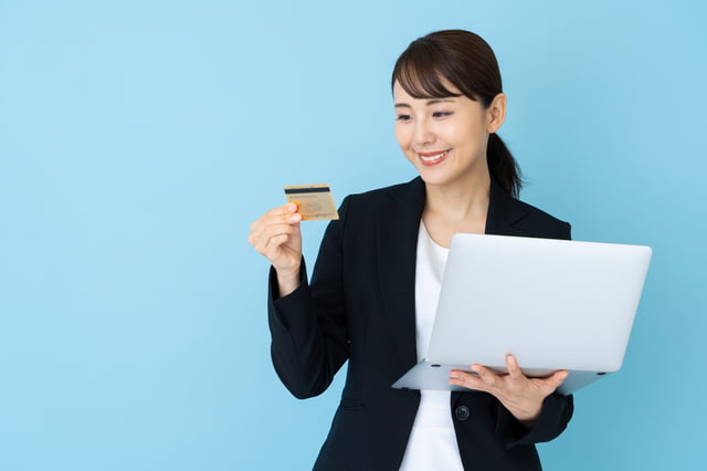 クレジットカード-パソコンとゴールドカードを持つ女性